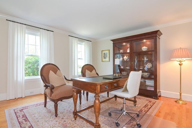 office area featuring light wood-style flooring, baseboards, and crown molding