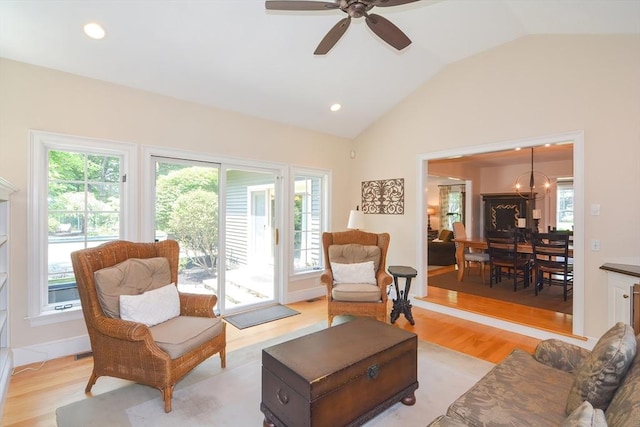 living room featuring light wood-type flooring, recessed lighting, ceiling fan with notable chandelier, and lofted ceiling