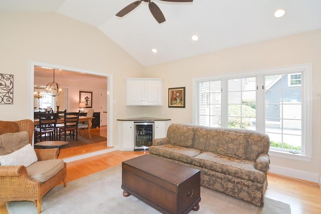 living room with recessed lighting, beverage cooler, baseboards, vaulted ceiling, and light wood-type flooring