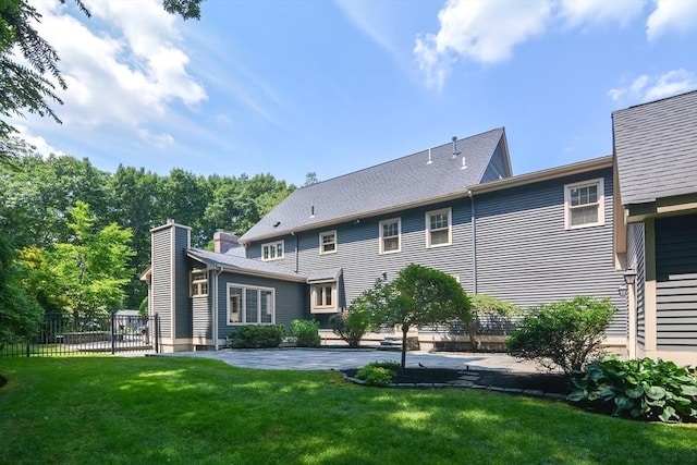 rear view of house with a yard, a patio, and fence