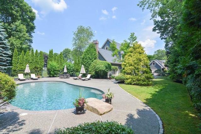 view of swimming pool with a patio, a lawn, fence, and a fenced in pool