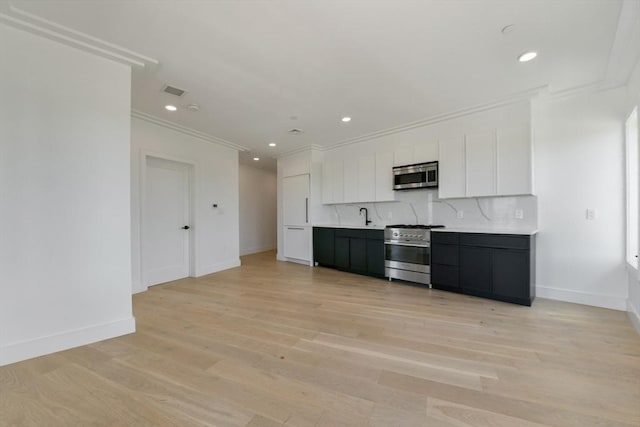 50 Leo M Birmingham Pkwy Unit 501, Boston, MA 02135 - kitchen featuring appliances with stainless steel finishes, crown molding, white cabinets, light countertops, and a sink