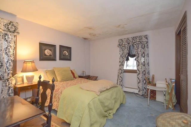 carpeted bedroom with a closet and baseboard heating