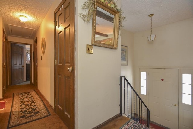 carpeted foyer featuring a textured ceiling and a wealth of natural light