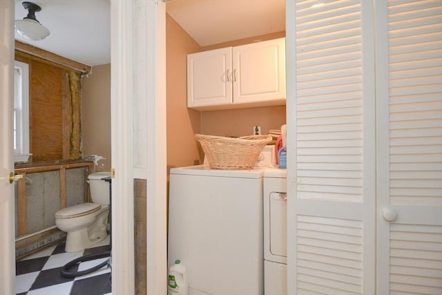 clothes washing area featuring cabinets and washer and dryer