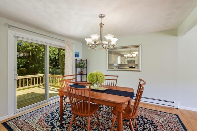 dining area featuring wood-type flooring, a chandelier, and baseboard heating