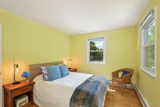 bedroom with light hardwood / wood-style flooring and a baseboard radiator