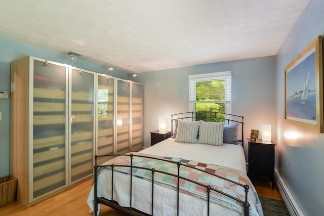 bedroom featuring hardwood / wood-style flooring and a baseboard radiator