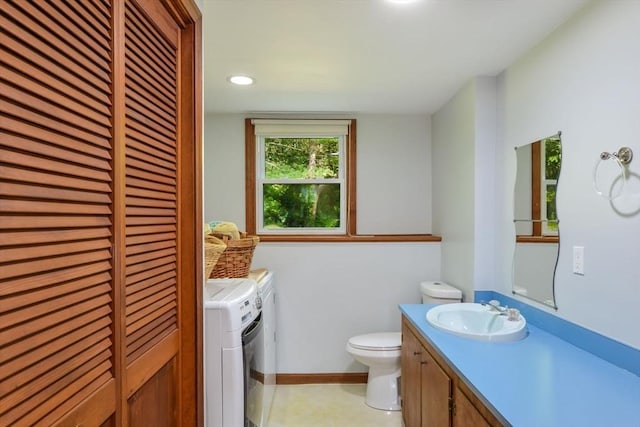 bathroom featuring vanity, independent washer and dryer, and toilet