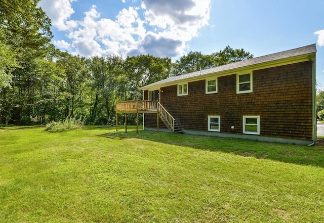 rear view of property with a yard and a deck