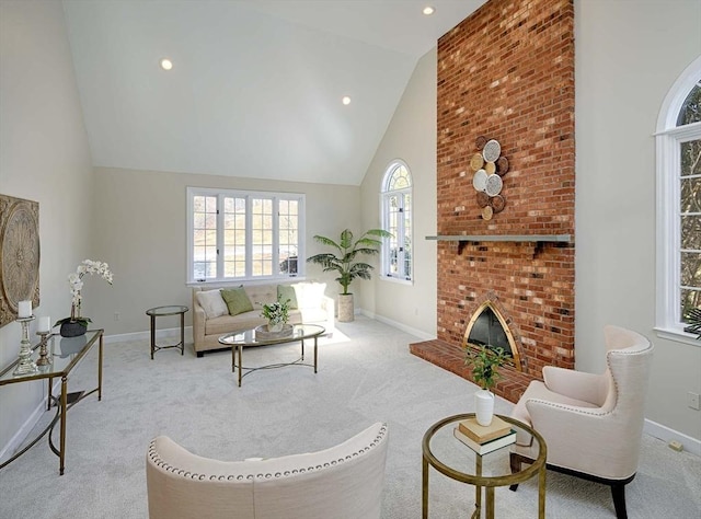 living room featuring a fireplace, high vaulted ceiling, and light carpet