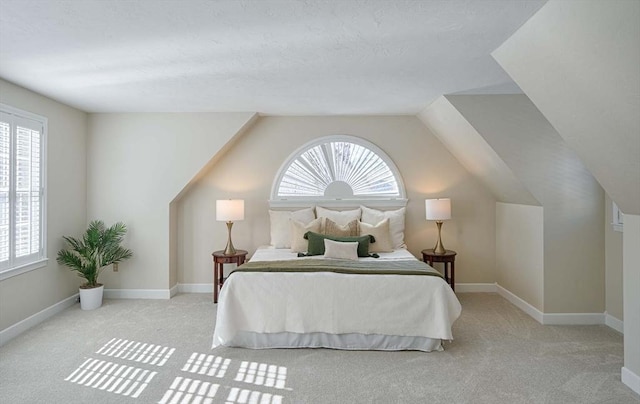 carpeted bedroom with multiple windows and lofted ceiling