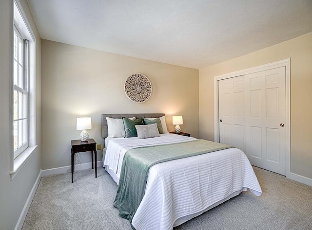 carpeted bedroom featuring multiple windows and a closet