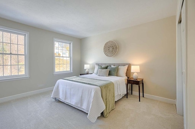 bedroom featuring multiple windows and light carpet