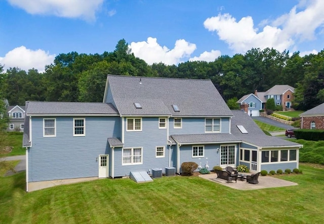 back of house with a lawn, a sunroom, a patio, and central air condition unit