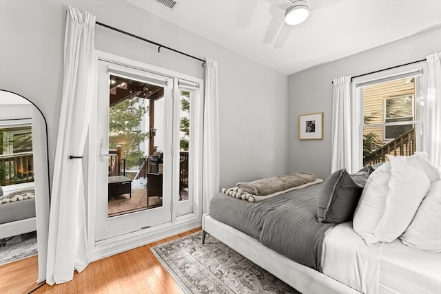 bedroom featuring hardwood / wood-style floors, ceiling fan, and access to outside