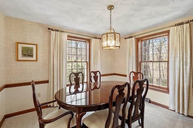 dining space featuring a healthy amount of sunlight, baseboards, and light colored carpet