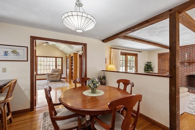 dining space with baseboards, beam ceiling, a ceiling fan, and wood finished floors