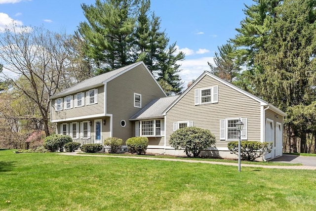 view of front of house featuring an attached garage, driveway, and a front yard