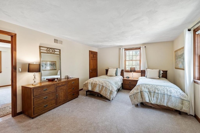 bedroom featuring visible vents and light carpet