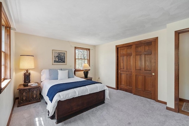 bedroom with carpet floors, baseboards, and a closet