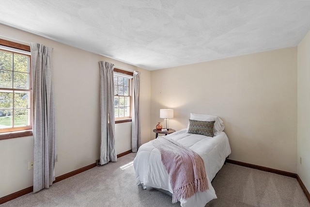 bedroom with baseboards and light colored carpet