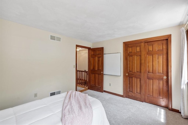 carpeted bedroom featuring baseboards and visible vents