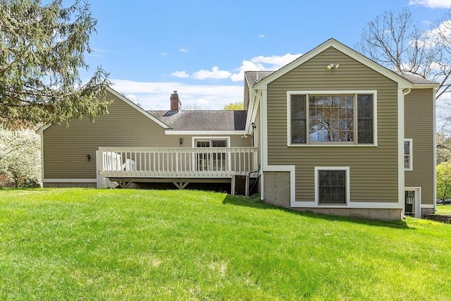 rear view of house with a lawn, a chimney, and a deck