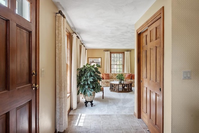 hallway featuring light colored carpet and light tile patterned floors