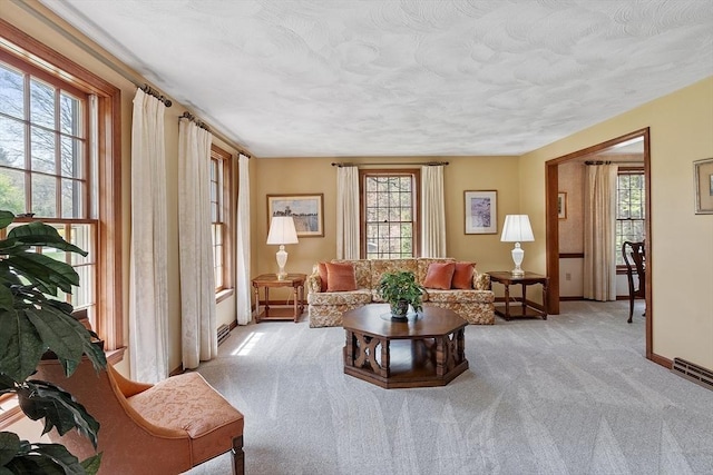 living room with baseboards, light carpet, and a wealth of natural light