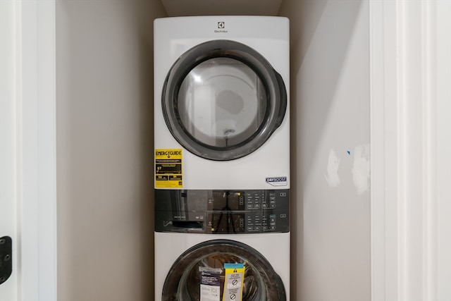 clothes washing area featuring stacked washer and dryer