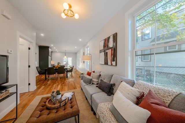 living room with light wood-type flooring and a notable chandelier