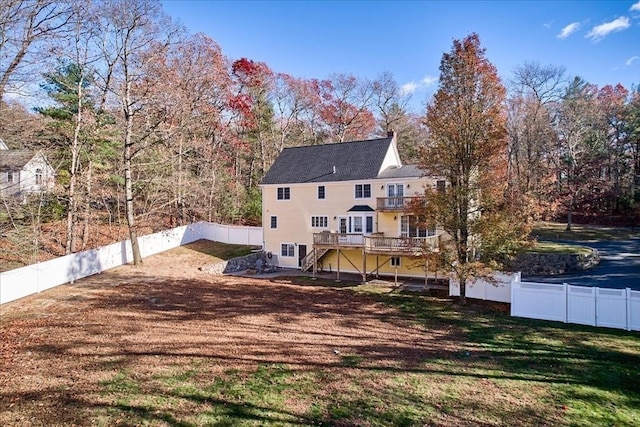 back of house featuring a lawn and a wooden deck