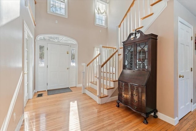 foyer with light hardwood / wood-style flooring and a high ceiling