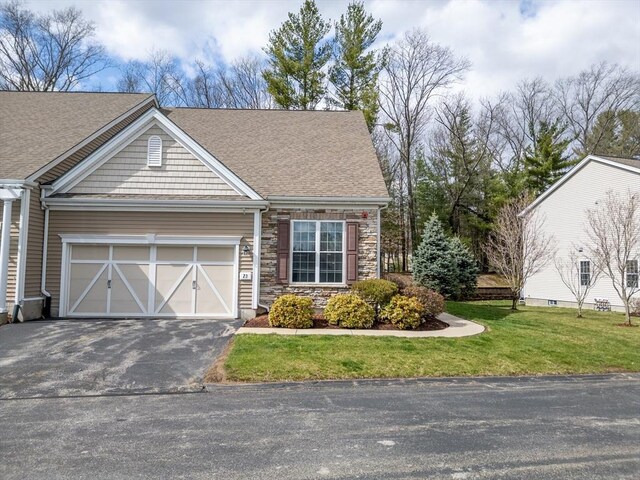 23 Kendall Ct Unit 23, Bedford, MA 01730 - view of front facade featuring roof with shingles, driveway, stone siding, an attached garage, and a front lawn