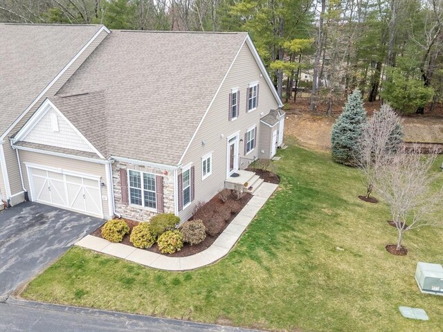 23 Kendall Ct Unit 23, Bedford, MA 01730 - exterior space with a yard, roof with shingles, stone siding, an attached garage, and driveway