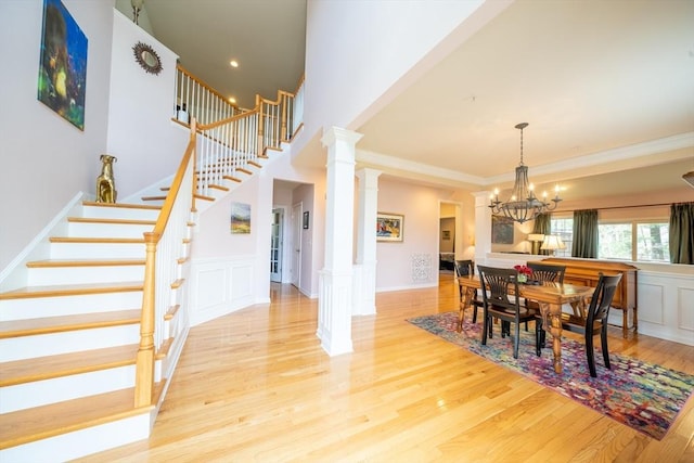 23 Kendall Ct Unit 23, Bedford, MA 01730 - dining space featuring crown molding, a decorative wall, stairway, a chandelier, and light wood finished floors