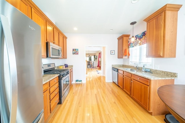 23 Kendall Ct Unit 23, Bedford, MA 01730 - kitchen featuring a sink, light wood-style flooring, light stone counters, and stainless steel appliances