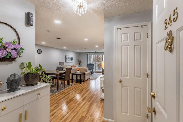 dining space featuring a textured ceiling and light hardwood / wood-style floors