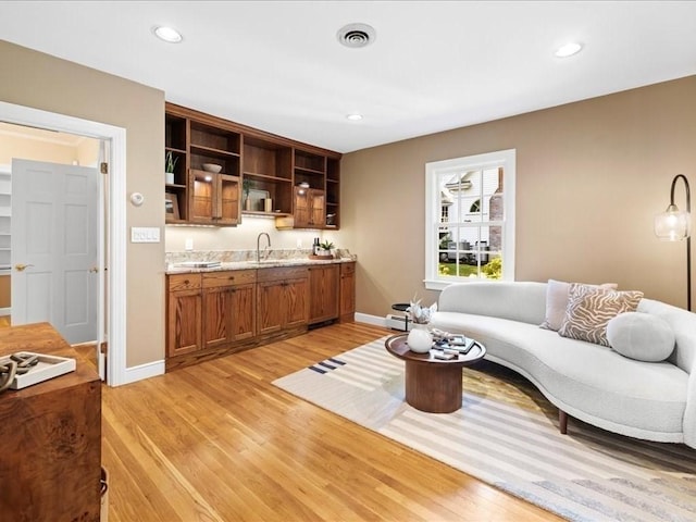 living room featuring sink and light hardwood / wood-style flooring