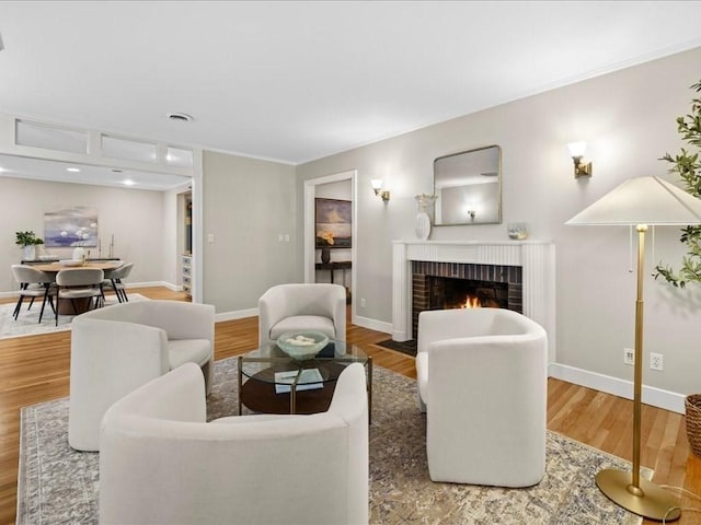 living room featuring hardwood / wood-style flooring and a brick fireplace