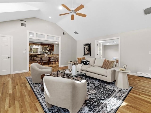 living room featuring a baseboard heating unit, high vaulted ceiling, ceiling fan, and light wood-type flooring