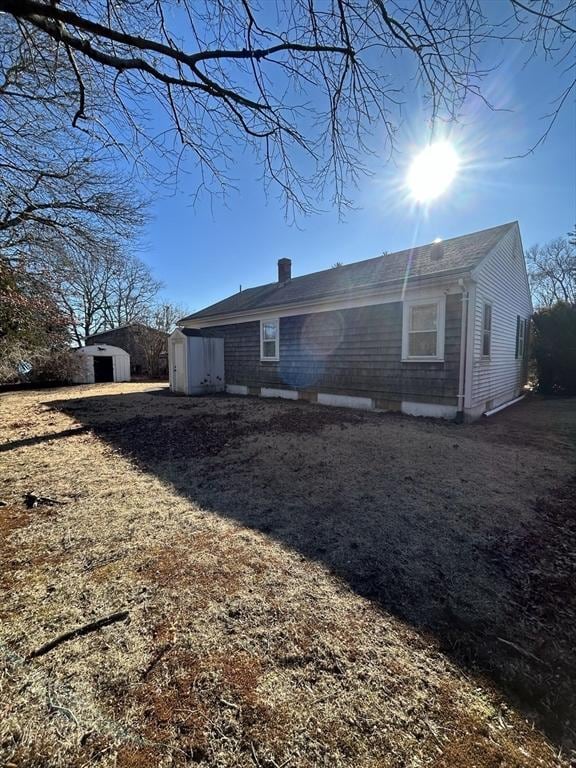 back of property featuring a storage unit