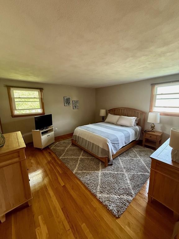 bedroom with a textured ceiling and wood finished floors