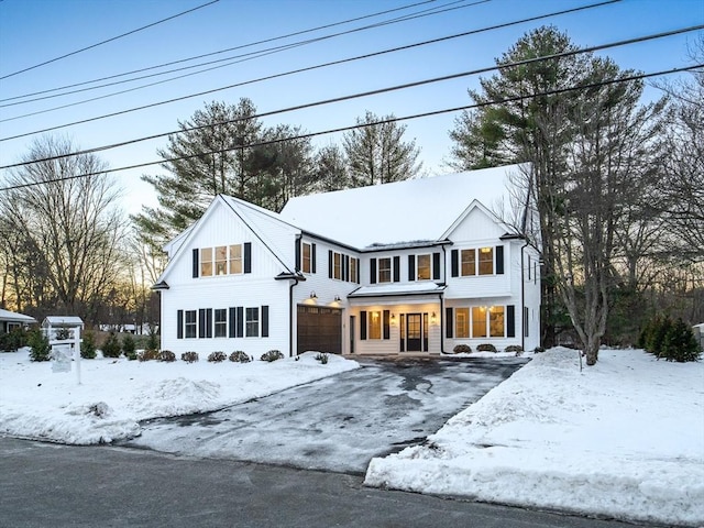 view of front facade featuring aphalt driveway, board and batten siding, and a garage