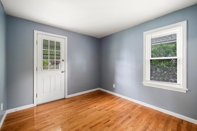 empty room with light hardwood / wood-style floors and a healthy amount of sunlight