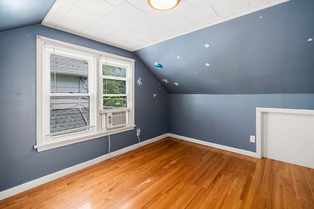 additional living space with vaulted ceiling and light hardwood / wood-style floors