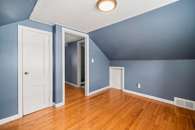 bonus room with light hardwood / wood-style flooring and vaulted ceiling