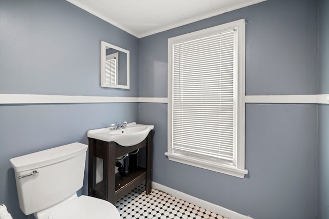 bathroom with crown molding, toilet, and tile patterned floors