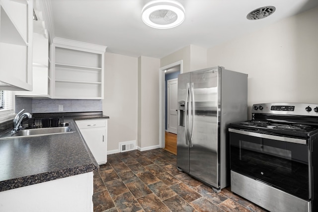 kitchen featuring sink, decorative backsplash, appliances with stainless steel finishes, and dark tile patterned floors